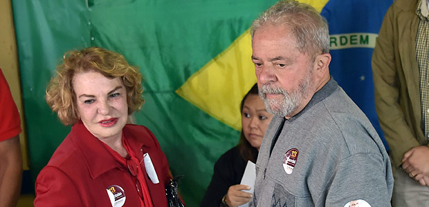 Brazilian former president Luiz Inacio Lula da Silva (R), of the Workers' Party (PT), is pictured with his wife Marisa Leticia at a polling station during the municipal elections' first round at a school in Sao Bernardo do Campo, 25 km south of Sao Paulo, Brazil, on October 2, 2016. Brazilians furious at recession and corruption voted Sunday in municipal elections amid heightened security after a series of murders of candidates. Among the first to cast his ballot in the financial capital Sao Paulo was Brazilian President Michel Temer from the center-left PMDB party, who took over the presidency in August after turning on his former leftist ally Dilma Rousseff and helping to force her from the top job in an impeachment vote. / AFP PHOTO / NELSON ALMEIDA