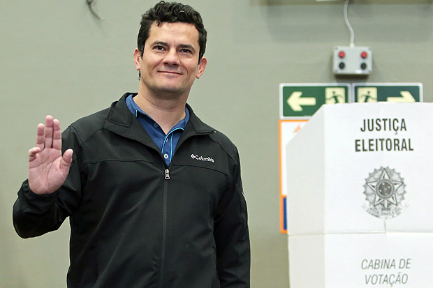 Brazilian Federal Judge Sergio Moro waves as he votes at a polling station during the mayoral election runoff in Curitiba, Brazil on October 30, 2016. Brazilians elect Sunday the authorities of 57 cities, including Rio de Janeiro, in a runoff election. / AFP PHOTO / Heuler Andrey