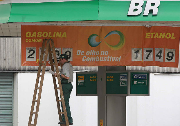 Em foto de arquivo, funcionrio de posto de gasolina em So Paulo altera tabela de preos