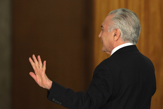 Brazil's President Michel Temer waves goodbye following his statement at Planalto presidential palace in Brasilia, Brazil, Wednesday, Aug. 2, 2017, after surviving a key congressional vote that could have suspended him over a bribery charge. The bribery allegation, which stunned even Brazilians inured to graft cases, was the latest in a bevy of scandals that has rocked the administration and created deep uncertainty and angst in Latin America's largest nation. (AP Photo/Eraldo Peres) ORG XMIT: ERA138