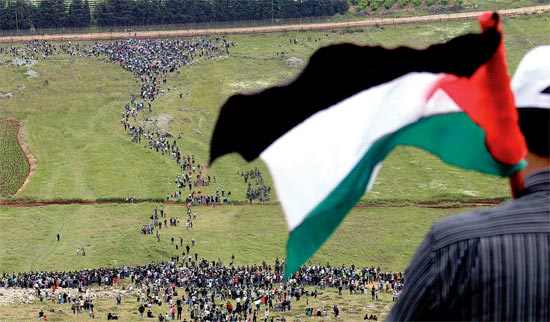 Manifestante agita bandeira palestina enquanto espera por outros em Marounal Rass, na fronteira com o sul do Líbano