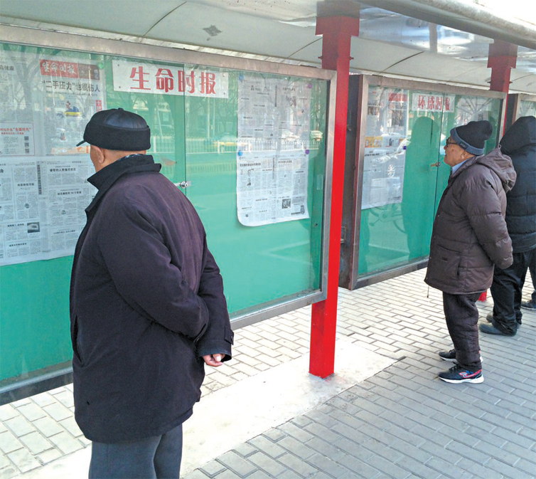 Moradores de Pequim leem jornais afixados em mural; profissionais veem presso maior