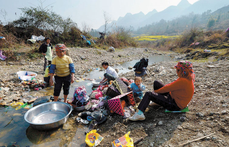 Chineses da zona rural lavam roupa em crrego perto da cidade de Anshun, na provncia de Guizhou 