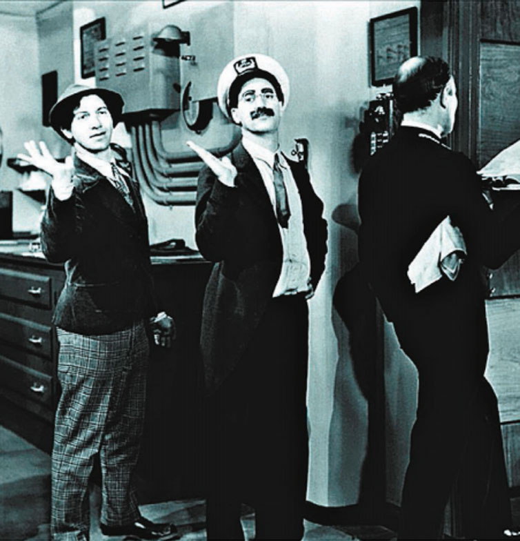 Os irmo comediantes Chico (esq.) e Groucho Marx (centro) 