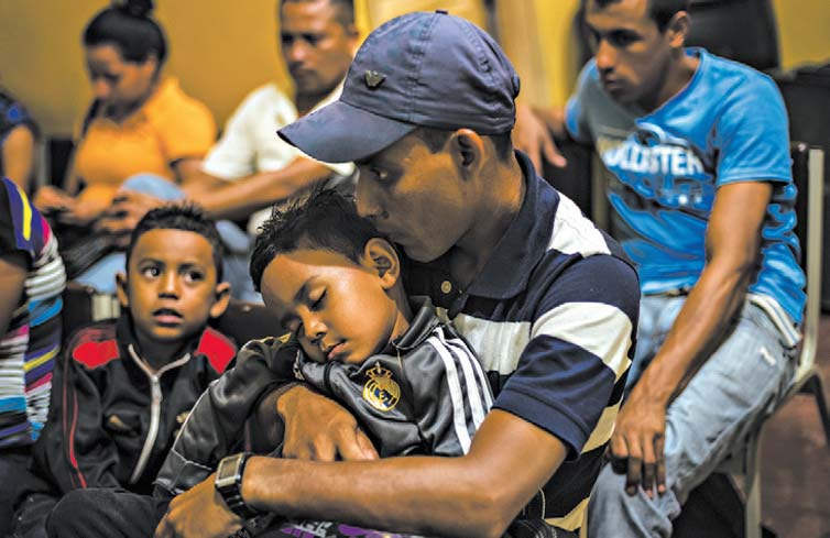 Numa estao rodoviria,hondurenhos esperam por nibus para deixarem a cidade