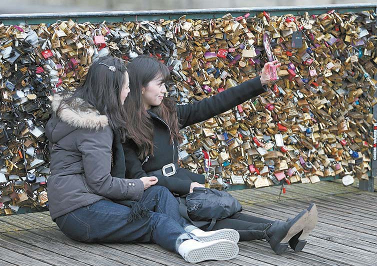 Turistas fotografam em ponte de Paris; prefeitura vai retirar cadeados, que ameaam estruturas