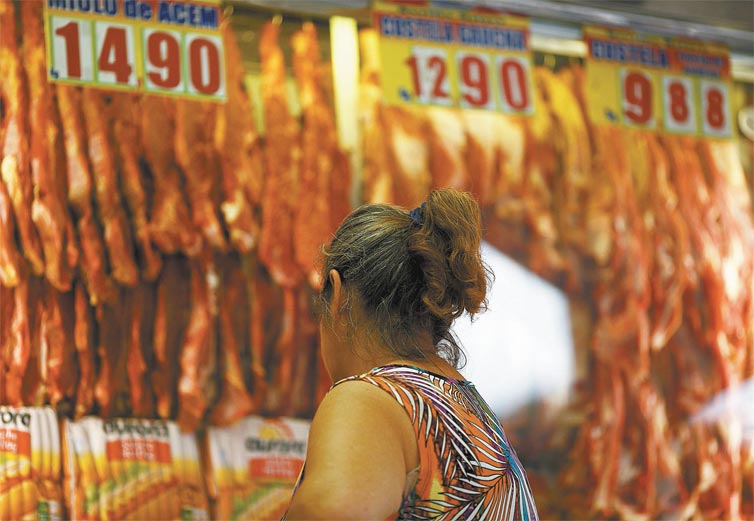 Consumidora checa preos em aougue na rua Frei Caneca, na Bela Vista, regio central de So Paulo