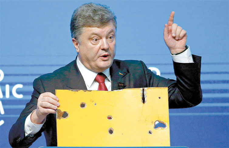 Presidente ucraniano, Petro Poroshenko, mostra pedaço de ônibus atingindo por estilhaços de míssil nas redondezas de Volnovakha