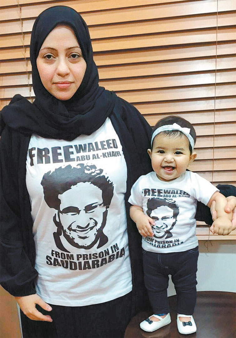Samar Badawi e sua filha posam com uma camiseta estampando o rosto do marido preso na Arbia Saudita
