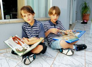 Os gêmeos Marco Antonio, João Antonio leem em casa; familia fez acordo com escola para libera-los da aula de religião 