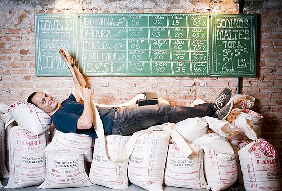 Lus Fabiani, 40, um dos scios da Cervejaria Nacional, em cima de sacos de malte