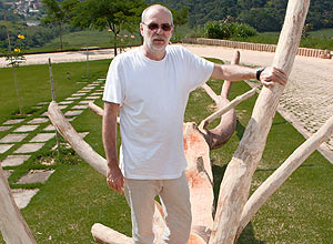 O artista Hugo Franca, que faz móveis com árvores no cemitério Memorial da Cerejeiras, na zona sul