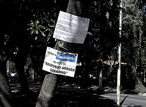 Cartazes afixados em uma arvore na av. Pedroso de Morais, no Alto de Pinheiros, avisam moradores sobre página virtual e paradeiro de sem-teto
