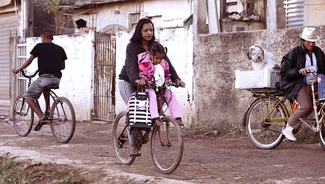 SO PAULO, SP, BRASIL, 23-08-2012: Comunidade do Jardim Helena, na Zona Leste de São Paulo, que utiliza a bicicleta como meio transporte. Mãe leva criança para creche na garupa da bicicleta(Foto: Christian von Ameln/Folhapress)