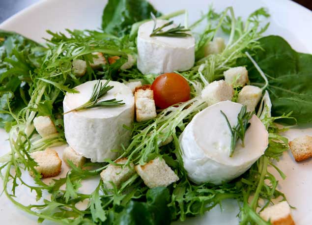 Salada de folhas verdes, alface "frisée", rúcula, queijo de cabra e "croûtons" com molho morno de ervas, do Reserva Bistrô