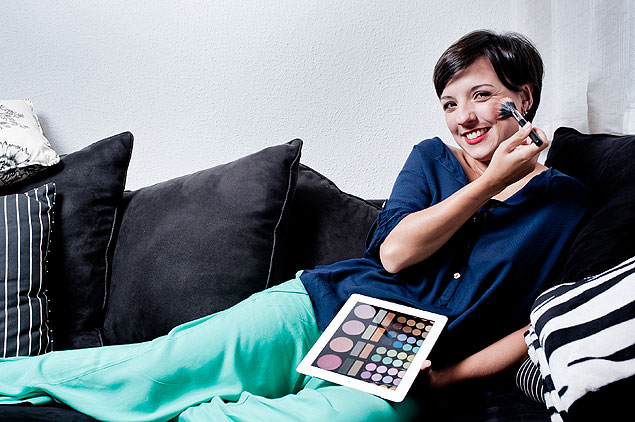 A produtora Junia Carmo, 30, que vive em São Paulo, usa o iPad para escolher maquiagens para entregar em hotel dos EUA 