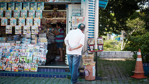 Homem l notcias de tabloides expostos em banca de jornais e revistas no distrito de Cursino, na regio sul da capital
