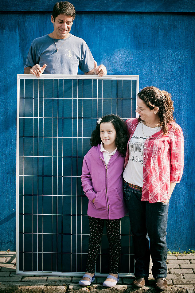 Carolina e Paulo Barros com a filha Isabel e o painel solar da casa, na Vila Madalena