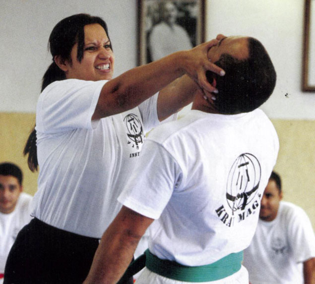 Mulher aplica golpe de Krav Maga durante aula em academia de luta