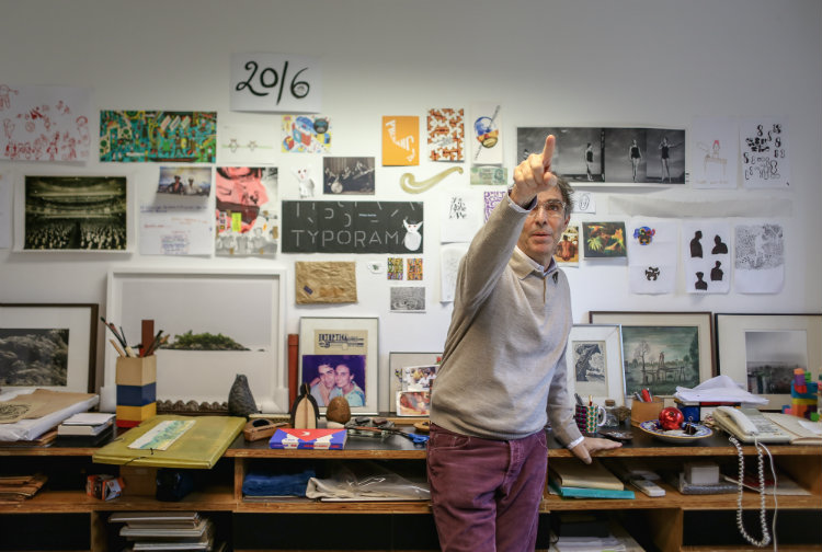 Designer paulistano Kiko Farkas aponta para torre de Lego sobre estante em sala de seu escritrio Mquina Estdio