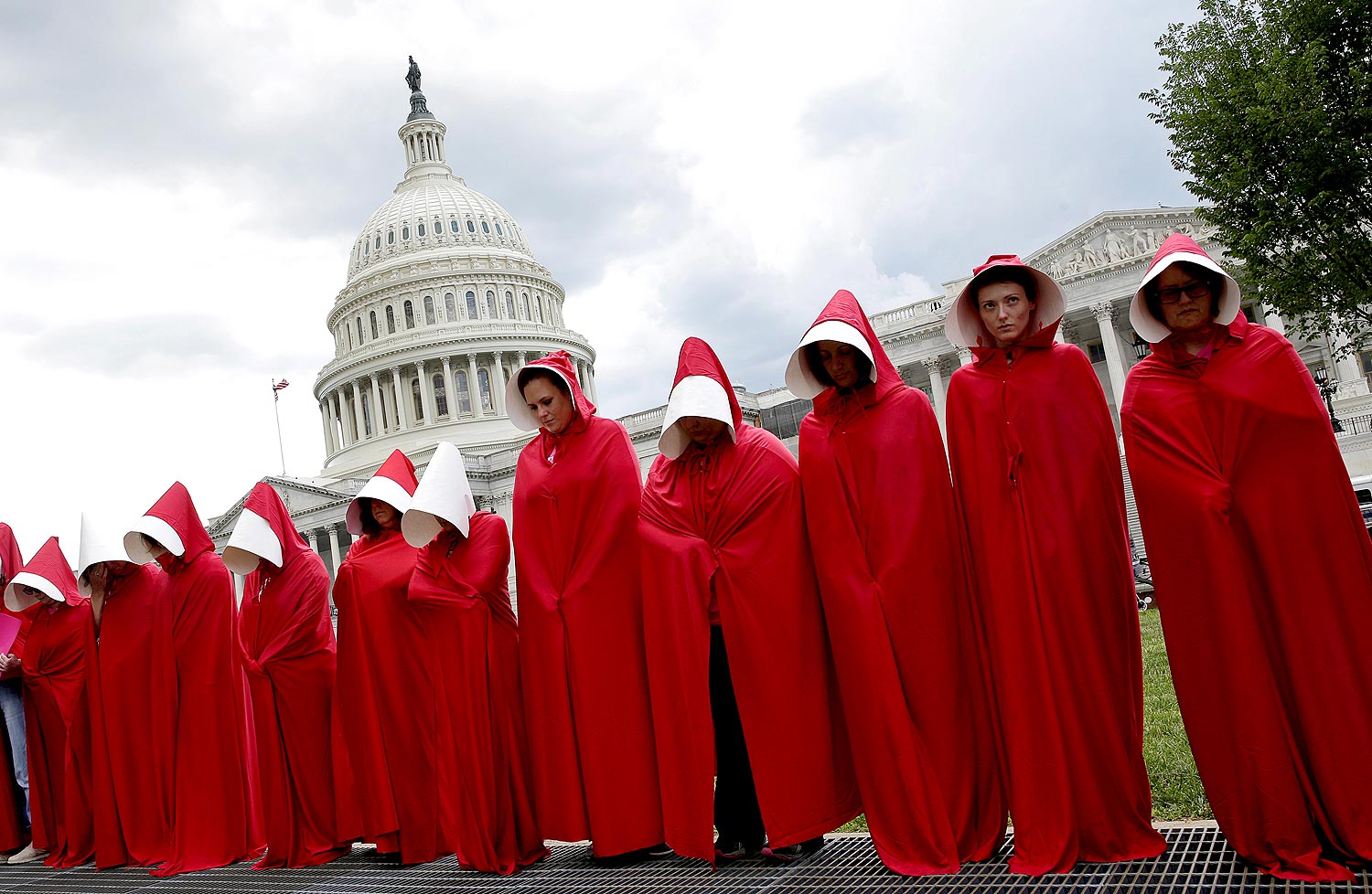 Mulheres vestidas como as aias do livro "O Conto da Aia" protestam contra os cortes no Planned Parenthood, em Washington, em julho