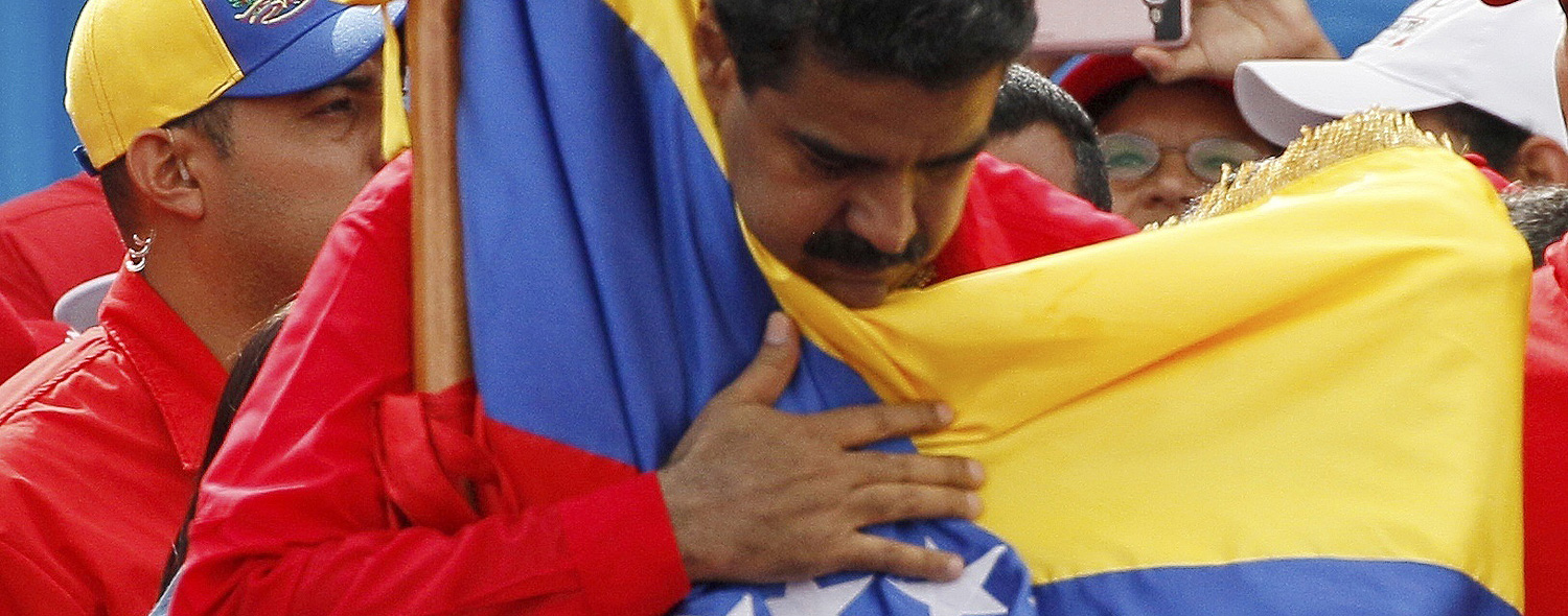 Venezuela's President Nicolas Maduro holds the country's national flag during a rally in Caracas, Venezuela, Thursday, July 27, 2017. President Maduro has provoked international outcry and enraged an opposition demanding his resignation with his push to elect an assembly that will rewrite the troubled South American nation's constitution. Sunday's election will cap nearly four months of political upheaval that has left thousands detained and injured and at least 100 dead. (AP Photo/Ariana Cubillos) ORG XMIT: XFLL126