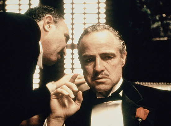 Marlon Brando como Don Corleone (dir.) em cena do filme "O Poderoso Chefão", tema da festa The Godfather