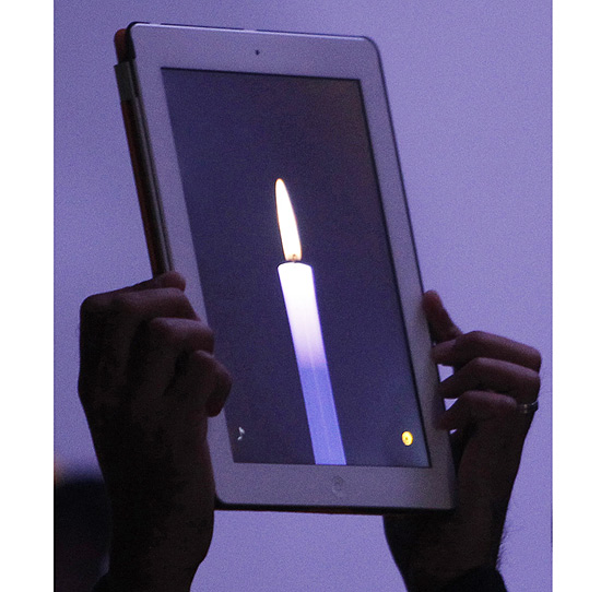 Homem segura iPad 2 com aplicativo de vela durante evento em homenagem a Steve Jobs