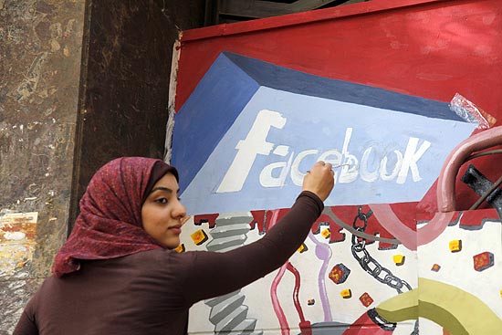 Estudante de arte da Universidade de Helwan, no Egito, pinta logo do Facebook