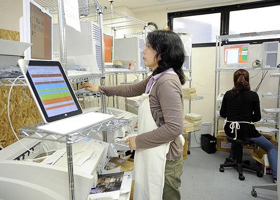 Funcionária escaneia livros na Bookscan, matriz japonesa da 1DollarScan, em Tóquio