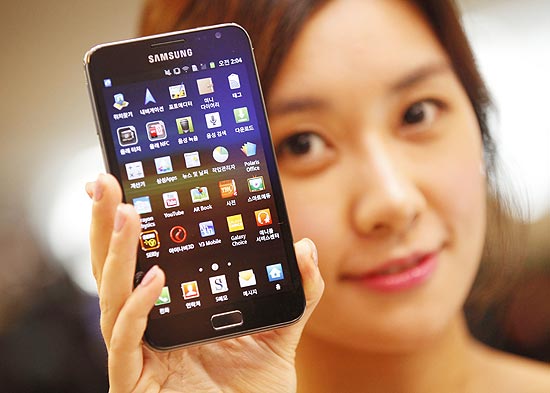 Modelo posa com o &quot;tabletphone&quot; Galaxy Note, durante evento na capital sul-coreana Seul; sucesso de aparelho causa surpresa 