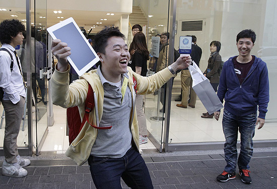 Consumidor festeja ao comprar o novo iPad na Coreia do Sul, onde o tablet está disponível desde 20 de abril
