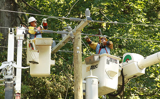 Homens tentam consertar cabos de energia em vizinhana de Virginia, EUA, aps tempestade