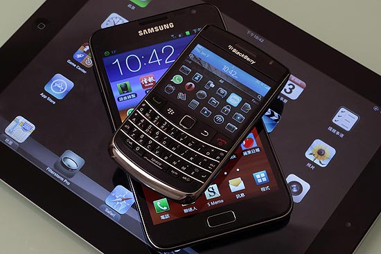 O "phablet" Samsung Galaxy Note entre um smartphone (BlackBerry Bold, no topo) e um tablet (iPad 2)
