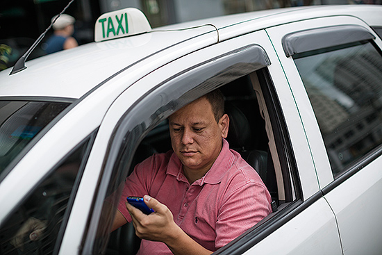O taxista Thiago Nunes Bastilha, 32, usa aplicativo no celular para encontrar passageiros prximos