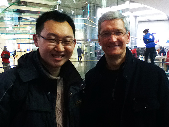 Tim Cook (dir.), executivo-chefe da Apple, posa para foto com f em loja da companhia americana em Pequim