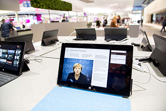 Estande da Microsoft com um tablet Surface exibindo a premi alem Angela Merkel durante a Cebit de 2013