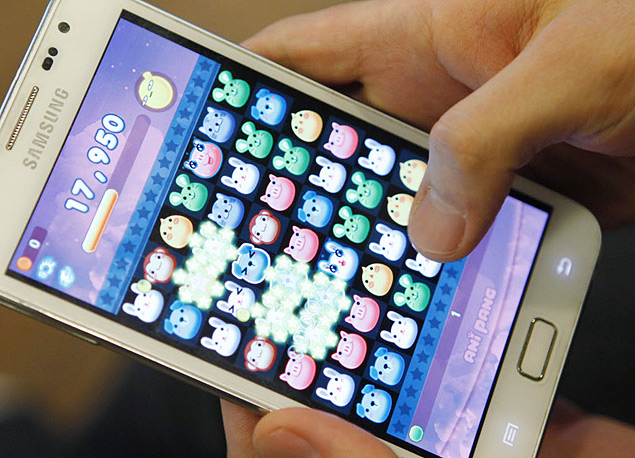 A SundayToz employee demonstrates the company's mobile game "Anipang" on a smartphone at the company in Seongnam, south of Seoul, March 26, 2013. Anipang went viral by piggybacking on popular mobile messenger KakaoTalk, which allowed friends to send in-game items and rank each other by score, netting creator SundayToz an average of $351,000 a day in October. The phenomenal success of GungHo Online Entertainment Inc's Puzzles and Dragons raises a $4.4 billion dollar question of what turns a mobile game into a star with staying power. Picture taken March 26, 2013. To match KOREA-MOBILE/GAMES REUTERS/Lee Jae-Won (SOUTH KOREA - Tags: BUSINESS SCIENCE TECHNOLOGY) ORG XMIT: SEO56