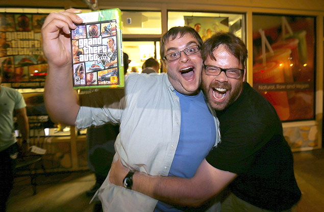 O jogador Casey Riffel segura sua cpia do recente "GTA 5" enquanto abraa o animador Michael Petterson