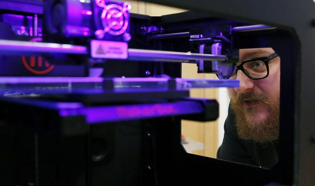 Instrutor de workshop sobre impresso 3D opera uma mquina MakerBot Replicator 2