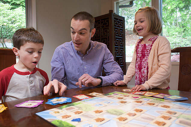 Dan Shapiro, centro, mostra aos filhos o jogo que inventou para ensinar programação em sua casa em Mercer Island, Washington (EUA)