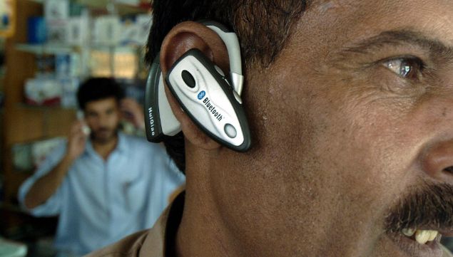 Homem testa um fone Bluetooth em loja de Islamabad, Paquisto