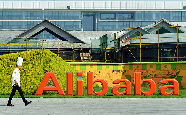 Pessoa caminha em frente ao logotipo da Alibaba na sede da empresa, em Hangzhou, China
