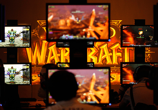 ORG XMIT: INA07 Visitors play ''World of Warcraft'' at an exhibition stand during the Gamescom 2011 fair in Cologne August 17, 2011. The Gamescom convention, Europe's largest video games trade fair, runs from August 17 to August 21. REUTERS/Ina Fassbender (GERMANY - Tags: BUSINESS SOCIETY)