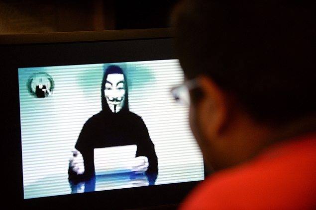 Imagem ilustrativa mostra pessoa em frente a PC exibindo vídeo que seria do Anonymous