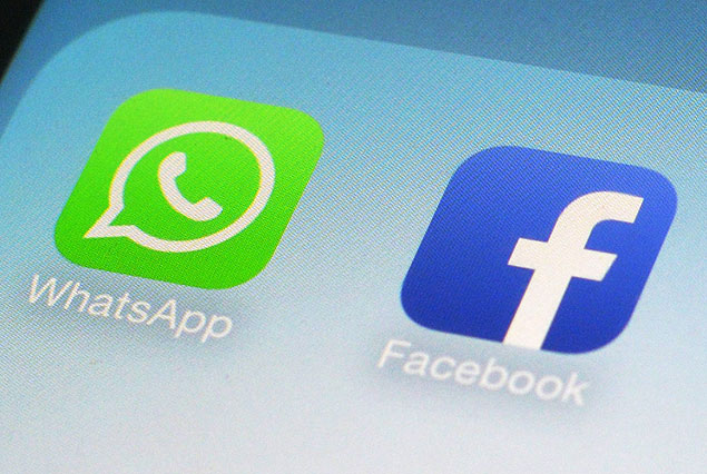 FILE - This Feb. 19, 2014 file photo shows WhatsApp and Facebook app icons on a smartphone in New York. One sign of the growing confidence in the US economy was an increase in corporate deals. One of the most high-profile was Facebook&#146;s $22 billion acquisition of the mobile-messaging application WhatsApp. (AP Photo/Patrick Sison, File) ORG XMIT: PAN103
