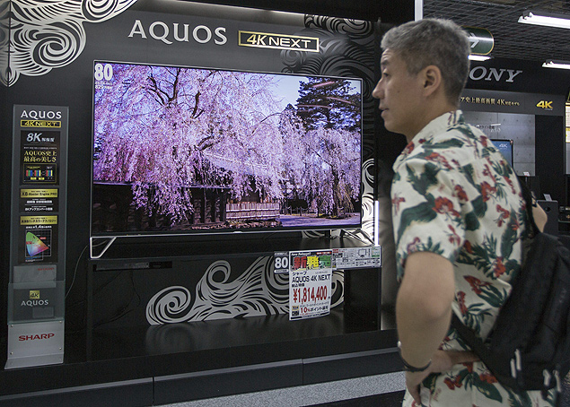 Consumidor em frente a uma TV da Sharp em loja de eletrnicos em Tquio