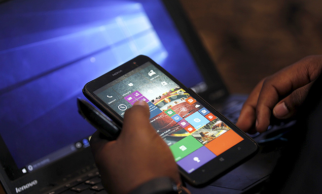 A Microsoft delegate checks applications on a smartphone during the launch of the Windows 10 operating system in Kenya's capital Nairobi, July 29, 2015. Microsoft Corp's launch of its first new operating system in almost three years, designed to work across laptops, desktop and smartphones, won mostly positive reviews for its user-friendly and feature-packed interface. REUTERS/Thomas Mukoya ORG XMIT: AFR114