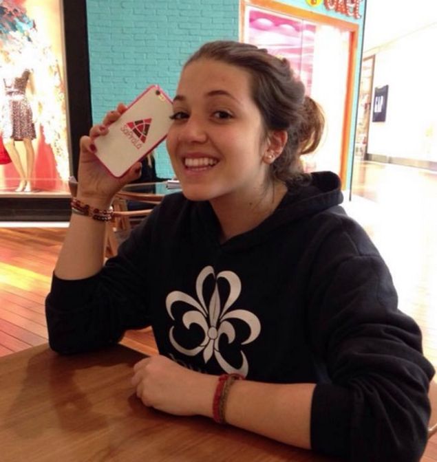 Catharina Doria, 17, criadora do Sai Pra L segura celular com a capinha do aplicativo