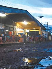 Moradores de Serra do Navio assistem a jogo de futebol no bar do Coronel, no centro da cidade